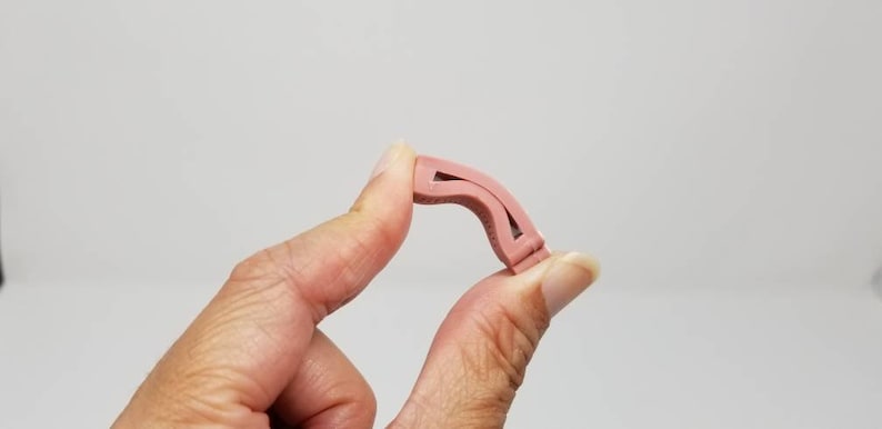 K&ouml;nnte beinhalten: Eine rosa Nasenklammer aus Kunststoff zum Schwimmen. Die Klammer ist so konzipiert, dass sie beim Schwimmen hilft, Wasser aus der Nase fernzuhalten.