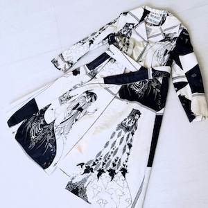 May include: A vintage, long-sleeved dress with a black and white art deco design. The dress features a collared neckline, a matching belt, and a pattern of figures and geometric shapes. The label reads "Bill Blass, Bond Street."