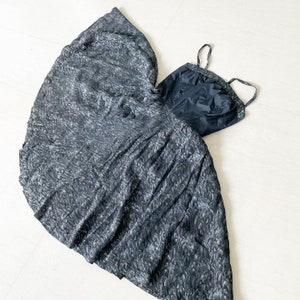 May include: A black and silver patterned dress with a black bodice and a full skirt. The dress has a strapless neckline and a fitted bodice.