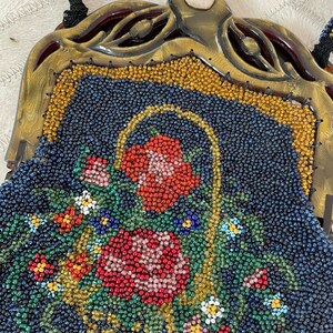 May include: A vintage beaded purse with a floral design. The purse is made of blue, green, red, and yellow beads. The purse has a gold-colored metal frame and a clasp.