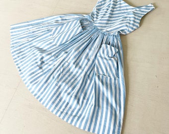 May include: A blue and white striped dress with a gathered skirt and two pockets. The dress has a sleeveless design and a scoop neck.