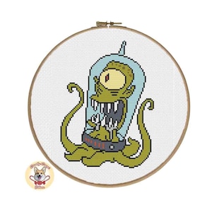 Puede incluir: Un patrón de punto de cruz de un extraterrestre verde con un ojo grande, que lleva un traje espacial azul y sostiene un arma. El extraterrestre está rodeado de tentáculos.