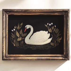 May include: A framed illustration of a white swan swimming in a pond with gold and green foliage. The swan has a red beak and white feathers. The background is black.