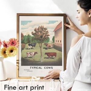 May include: A framed vintage print of a farm scene with five cows in a field. The print is titled "Typical Cows" and includes the breeds Holstein and Ayrshire. The print is in a brown frame and is hanging on a white wall.