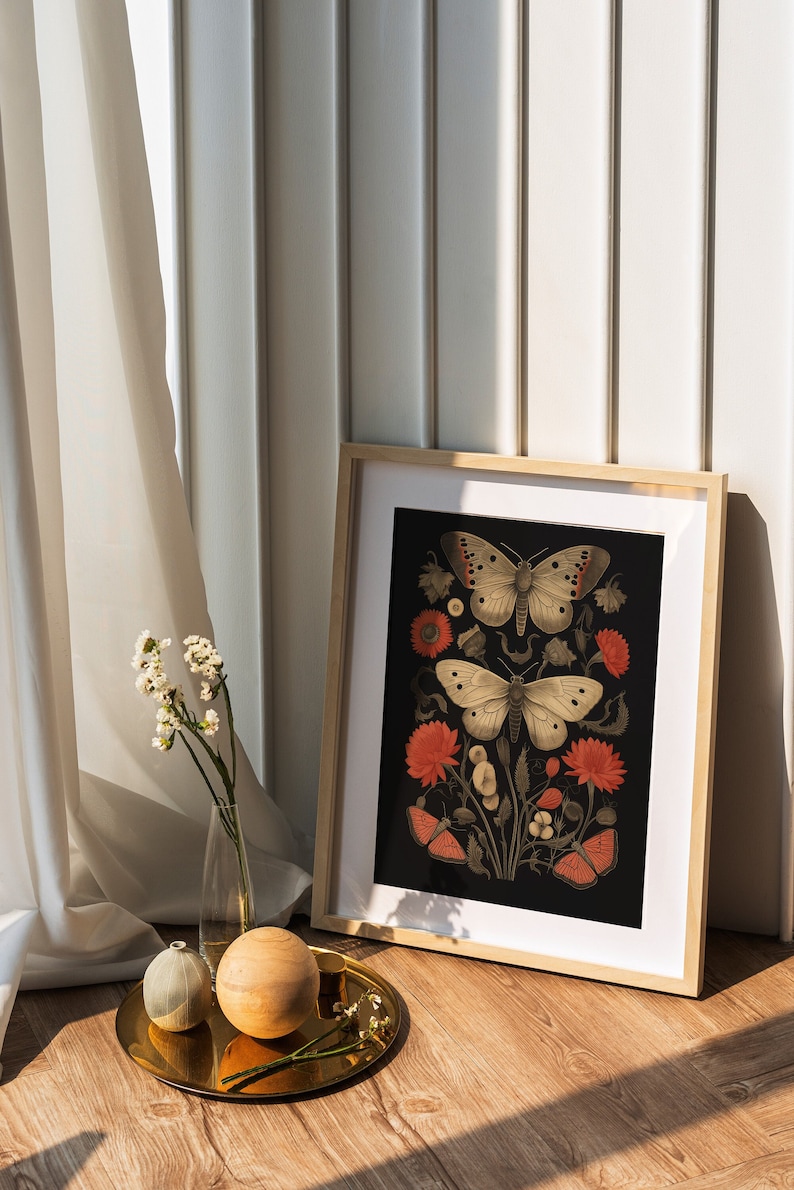 K&ouml;nnte beinhalten: Ein gerahmter Druck mit schwarzem Hintergrund, der drei Schmetterlinge und rote Blumen zeigt. Die Schmetterlinge sind wei&szlig; mit schwarzen Markierungen und die Blumen sind tiefrot.