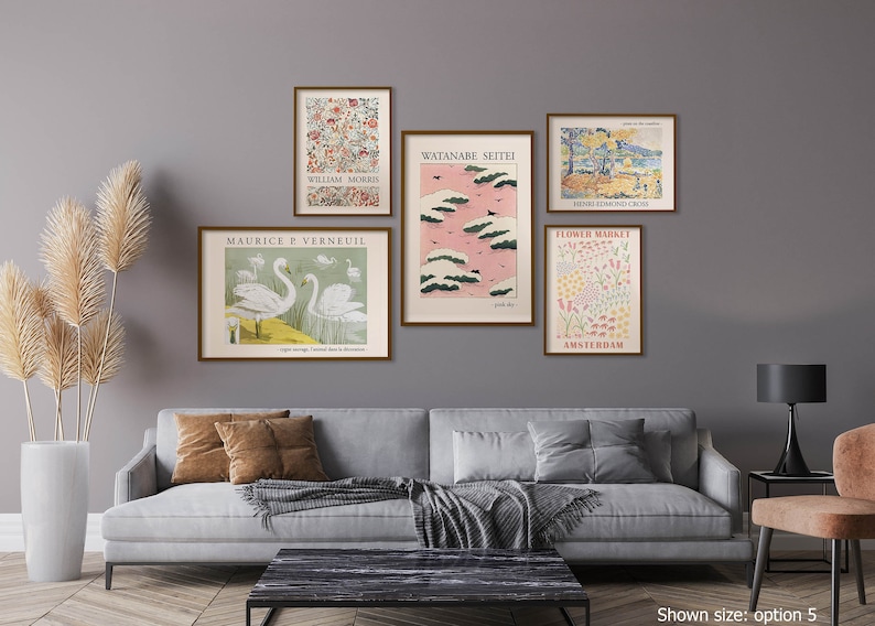 May include: A living room interior with a gray sofa and a black coffee table. Five framed prints are hung on the wall above the sofa. The prints feature various designs, including floral patterns, landscapes, and birds. The prints are all in a similar style, with a vintage aesthetic.