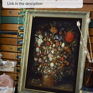 Peut inclure: Une impression encadr&eacute;e d'une nature morte repr&eacute;sentant un vase rempli de fleurs color&eacute;es. Le cadre est de couleur or fonc&eacute; avec des d&eacute;tails orn&eacute;s. L'impression est disponible &agrave; l'achat avec un lien dans la description.