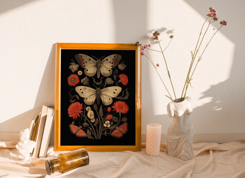 K&ouml;nnte beinhalten: Ein gerahmter Druck mit schwarzem Hintergrund, der zwei Schmetterlinge und rote Blumen zeigt. Die Schmetterlinge sind wei&szlig; mit schwarzen Markierungen und die Blumen sind tiefrot.