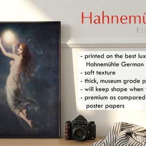 May include: A framed print of a woman reaching up to touch a glowing orb in a dark sky. The print is on Hahnem&uuml;hle German Etching paper, which is known for its soft texture and museum-grade quality.