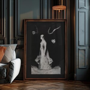 May include: A black and white framed print of a woman in a long dress standing in front of a dark background. There are three abstract shapes above her head.