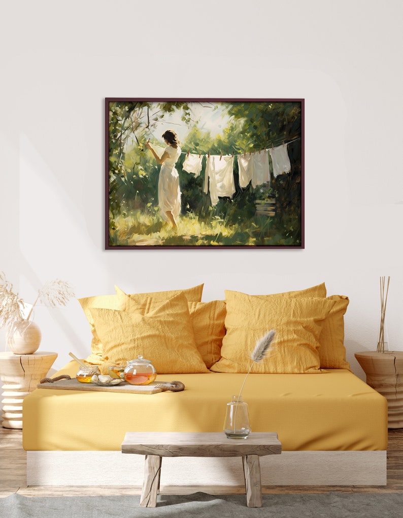 Puede incluir: Una pintura de una mujer colgando la ropa en un tendedero en un jard&iacute;n verde. La mujer lleva un vestido blanco y la ropa es blanca.