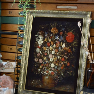 Peut inclure: Une impression encadr&eacute;e d'une nature morte repr&eacute;sentant un vase rempli d'un assortiment de fleurs color&eacute;es. Les fleurs sont dispos&eacute;es de mani&egrave;re sym&eacute;trique et comprennent des roses, des tulipes et des lys. Le vase est de couleur brun fonc&eacute; et repose sur un fond sombre.