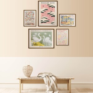 May include: Five framed art prints on a beige wall with a wooden bench and a woven lamp in front of the wall. The prints feature a variety of subjects, including flowers, birds, and landscapes. The prints are all in a similar style, with a vintage aesthetic.