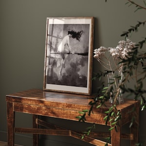 May include: A black and white framed print of a woman riding a broomstick in a cloudy sky.