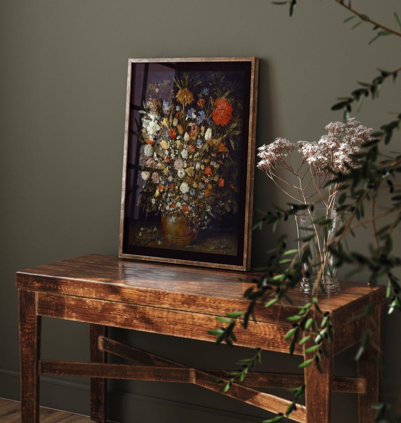 Peut inclure: Une impression encadr&eacute;e d'une nature morte repr&eacute;sentant un vase rempli de fleurs color&eacute;es. Le vase est brun et l'arri&egrave;re-plan est sombre.