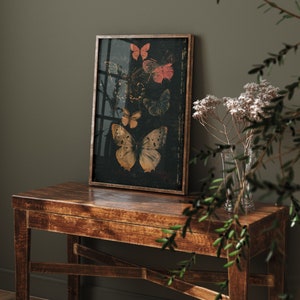 May include: A framed print of a dark background with five butterflies in various shades of orange, yellow, red, and blue. The butterflies are arranged in a vertical pattern, with the largest butterfly at the bottom.