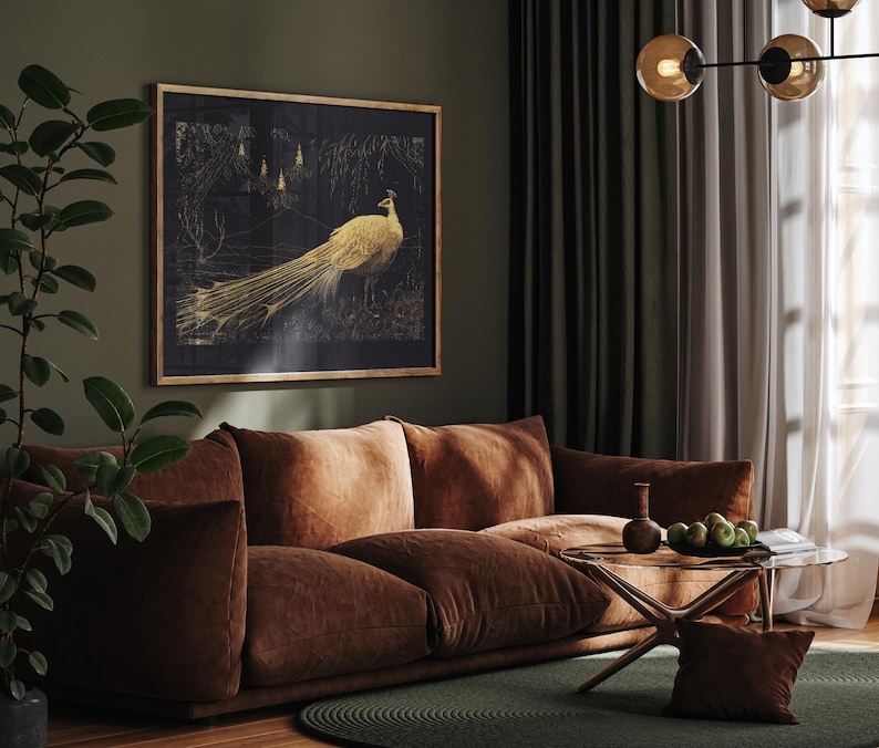 Puede incluir: Un sof&aacute; de terciopelo marr&oacute;n con una obra de arte enmarcada con una impresi&oacute;n de pavo real dorado colgada encima. El sof&aacute; est&aacute; en una sala de estar con una mesa de caf&eacute; de vidrio y una alfombra verde.