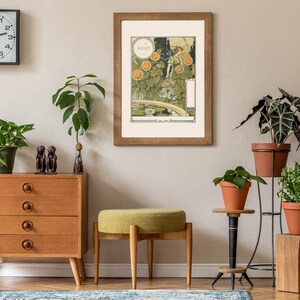 Puede incluir: Un interior de sala de estar con una c&oacute;moda de madera, un taburete tapizado verde y una impresi&oacute;n enmarcada de una mujer en un jard&iacute;n. La impresi&oacute;n se titula "Aout" y presenta a una mujer con un vestido verde de pie en un jard&iacute;n con girasoles y un estanque. Hay varias plantas en macetas en toda la habitaci&oacute;n, incluida una planta grande en una maceta de terracota sobre un soporte de metal.