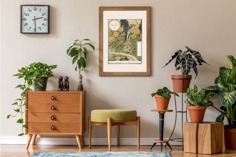 Puede incluir: Un interior de sala de estar con una c&oacute;moda de madera, un taburete tapizado verde y una impresi&oacute;n enmarcada de una mujer en un jard&iacute;n. La impresi&oacute;n se titula "Aout" y presenta a una mujer con un vestido verde de pie en un jard&iacute;n con girasoles y un estanque. Hay varias plantas en macetas en toda la habitaci&oacute;n, incluida una planta grande en una maceta de terracota sobre un soporte de metal.