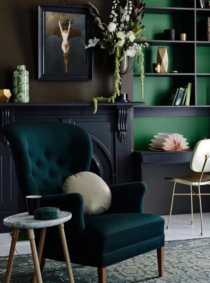 Op de afbeelding: Een donkergroene fluwelen fauteuil met een gouden kussen staat in een kamer met een donkergroen en bruin kleurenschema. Een zwarte open haard met een gouden decoratief element bevindt zich achter de fauteuil. Een kleine ronde tafel met een wit marmeren blad staat voor de fauteuil.