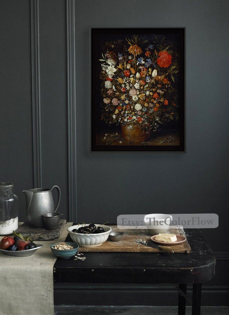 Peut inclure: Une impression encadr&eacute;e d'une nature morte repr&eacute;sentant un vase rempli de fleurs color&eacute;es. Le vase est brun et les fleurs sont dispos&eacute;es de mani&egrave;re sym&eacute;trique. L'arri&egrave;re-plan est sombre et le tableau est encadr&eacute; de noir.