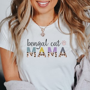 May include: White t-shirt with the text "bengal cat" and a paw print, followed by the word "MAMA" in colorful letters with a leopard print pattern.