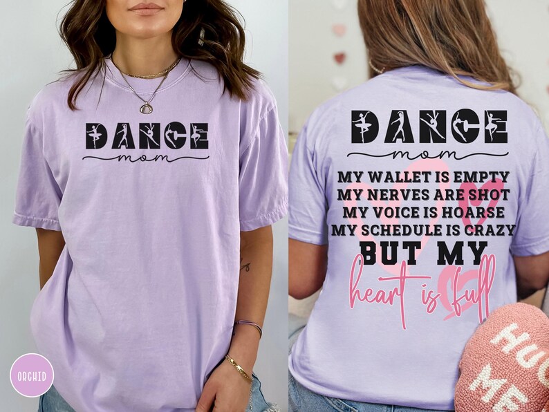 May include: A light purple short-sleeve t-shirt. The front features the black text DANCE mom with ballet silhouettes. The back displays DANCE mom, MY WALLET IS EMPTY, MY NERVES ARE SHOT, MY VOICE IS HOARSE, MY SCHEDULE IS CRAZY BUT MY heart is full.