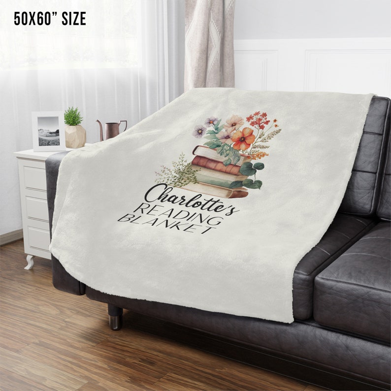 May include: A white fleece blanket with a floral design and the text "Charlotte's Reading Blanket" printed on it. The blanket is 50x60 inches.