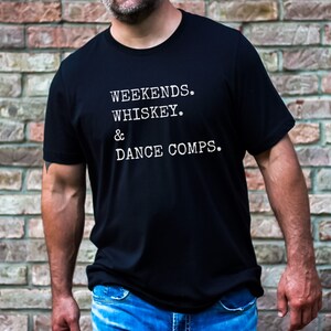 May include: A black t-shirt with white text that reads "Weekends. Whiskey. & Dance Comps."