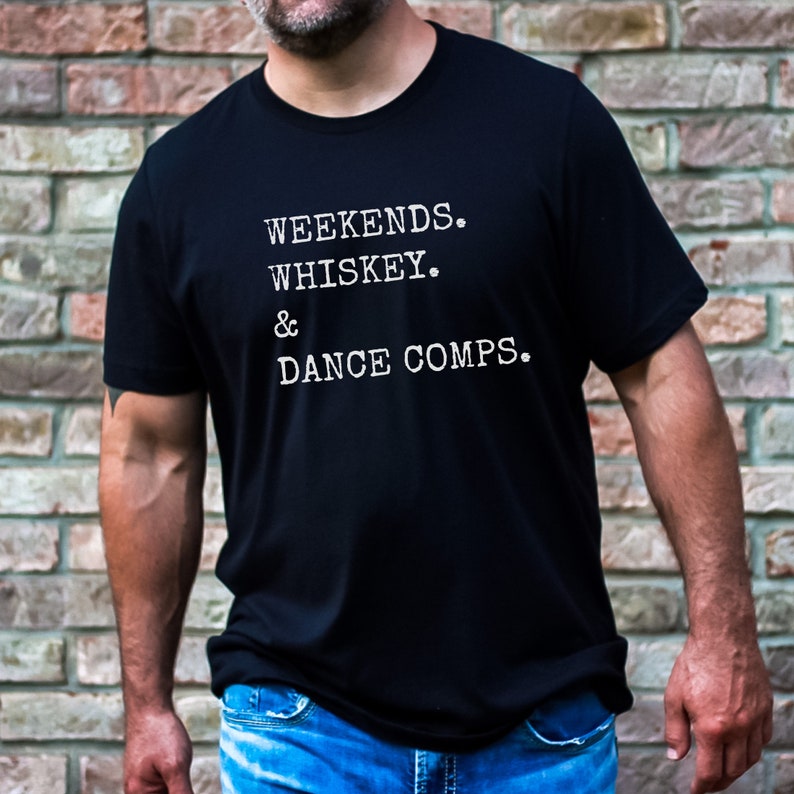 May include: A black t-shirt with white text that reads "Weekends. Whiskey. & Dance Comps."