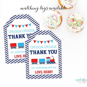 Peut inclure: Deux &eacute;tiquettes de remerciement ray&eacute;es bleu et blanc avec un motif de train rouge, bleu et blanc. Le texte sur les &eacute;tiquettes est "Chugga Chugga Thank You" et "for celebrating with me! Love, Henry".