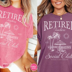 Puede incluir: Dos camisetas, una rosa y otra morada, cada una con un gr&aacute;fico blanco. El gr&aacute;fico incluye las palabras "Retired Teachers Social Club" con palmeras, una sombrilla y el a&ntilde;o 2025. Tambi&eacute;n se incluye la frase "School's Out Forever".