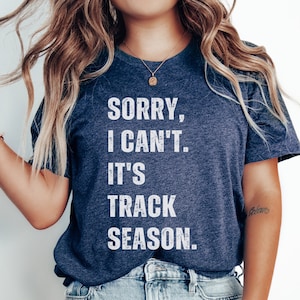 May include: A navy blue t-shirt with white text that reads "Sorry, I can't. It's track season."