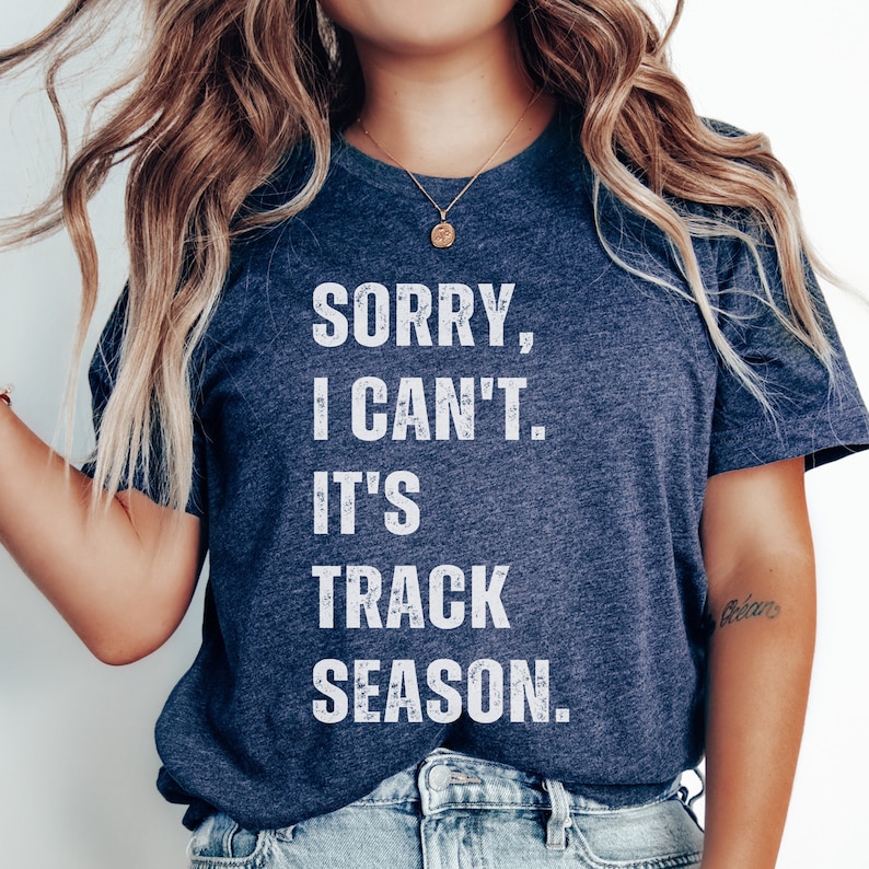May include: A navy blue t-shirt with white text that reads "Sorry, I can't. It's track season."