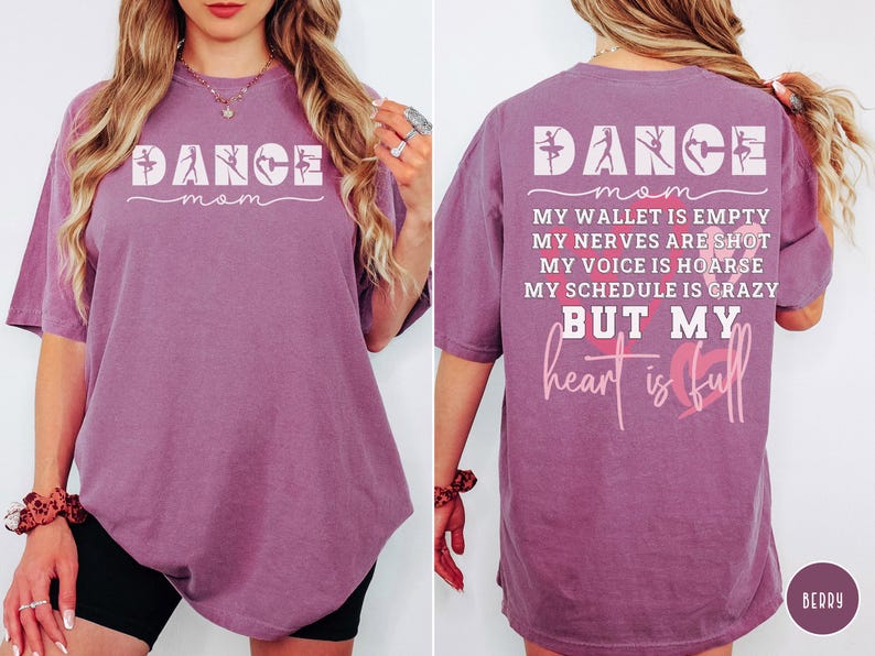 May include: A berry-colored short-sleeve t-shirt featuring the white text DANCE MOM on the front. The back displays the text DANCE MOM, MY WALLET IS EMPTY, MY NERVES ARE SHOT, MY VOICE IS HOARSE, MY SCHEDULE IS CRAZY BUT MY heart is full with hearts.