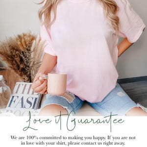 Peut inclure: Un t-shirt rose avec le texte "Love it Guarantee" en lettres vertes. Le texte ci-dessous indique "We are 100% committed to making you happy. If you are not in love with your shirt, please contact us right away. All items are made to order so we do not accepted returns but a replacement can be sent if there are any issues. Thank you for supporting our small, family run business. :)"