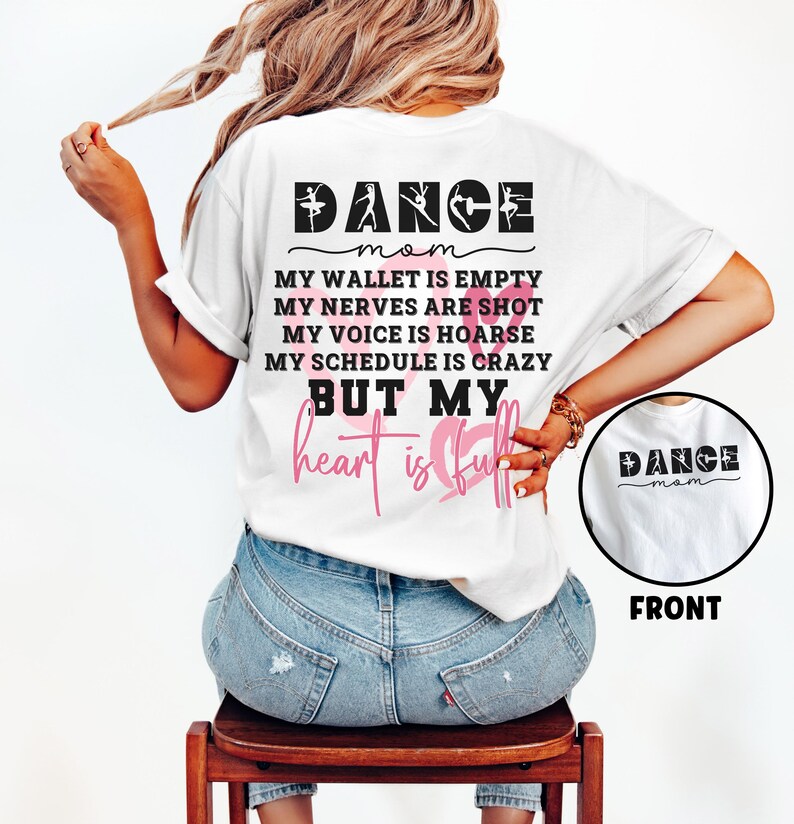 May include: A white t-shirt featuring black text that reads DANCE MOM, MY WALLET IS EMPTY, MY NERVES ARE SHOT, MY VOICE IS HOARSE, MY SCHEDULE IS CRAZY, BUT MY heart is full, with pink heart outlines and a small circular front view inset.