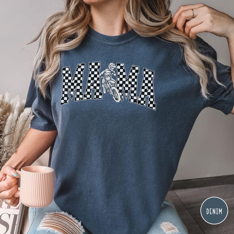 Peut inclure: Un t-shirt bleu marine avec un motif &agrave; carreaux blancs qui &eacute;pelle "MAMA" avec un graphique de pilote de motocross au centre.