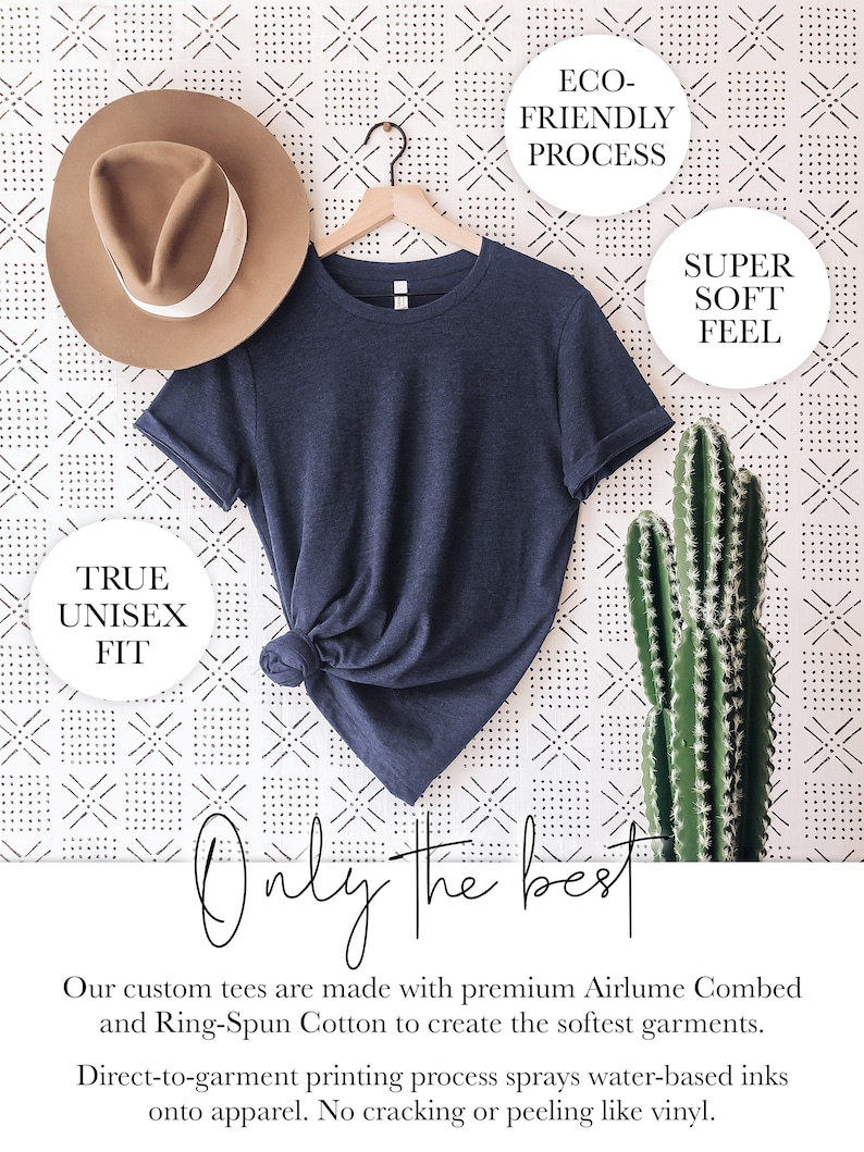May include: A navy blue t-shirt hanging on a wooden hanger against a white background with a black and white geometric pattern. The t-shirt is made with premium Airlume Combed and Ring-Spun Cotton. The text "ECO-FRIENDLY PROCESS", "SUPER SOFT FEEL", and "TRUE UNISEX FIT" are visible in white circles. The text "Only the best" is written in black cursive.