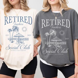 Puede incluir: Dos camisetas, una marfil y otra color pimienta, cada una con un dise&ntilde;o de playa. El dise&ntilde;o incluye las palabras "RETIRED Teachers Social Club" con palmeras, un sol y el a&ntilde;o 2025.