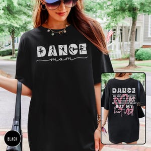 May include: A black t-shirt featuring the white text DANCE mom with silhouettes of dancers inside the letters. The back of the shirt displays the same text above the words MY WALLET IS EMPTY MY NERVES ARE HOT MY VOICE IS HOARSE MY SCHEDULE IS CRAZY BUT MY heart is full.