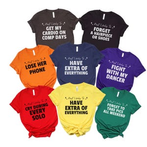May include: A set of ten colorful t-shirts with white text that says "Most Likely To" followed by a humorous phrase. The phrases include "Get My Cardio On Comp Days", "Forget A Hairpiece Or Shoes", "Lose Her Phone", "Have Extra Of Everything", "Fight With My Dancer", "Cry During Every Solo", "Have Extra Of Everything", "Forget To Take Pics All Weekend".