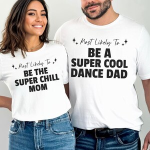 May include: Two white t-shirts with black text. The shirt on the left says "Most Likely To Be The Super Chill Mom". The shirt on the right says "Most Likely To Be A Super Cool Dance Dad".