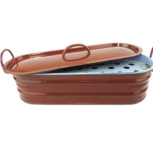 Puede incluir: Una fuente para asar de esmalte rojo con tapa e inserto perforado extraíble. La fuente tiene dos asas a los lados y una en la tapa.