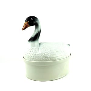 May include: White ceramic swan-shaped casserole dish with a black and white painted head and a brown beak.