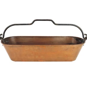 Pode incluir: Um vaso de cobre com uma alça de metal preto. O vaso tem formato oval e tem um aspecto rústico.