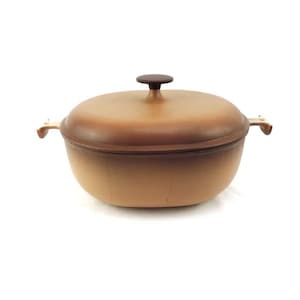 以下が含まれることがあります： ふたとハンドルが2つ付いた、茶色の楕円形の鋳鉄製のダッチオーブン。オーブンは薄い茶色の釉薬で覆われています。