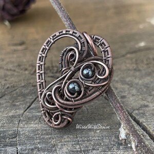 Heart-shaped antiqued and polished copper pendant with two small round Hematite beads.