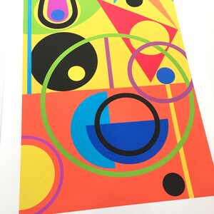 May include: Abstract geometric art print with a colorful design featuring circles, semi-circles, triangles, and squares in shades of yellow, red, green, blue, black, and purple.