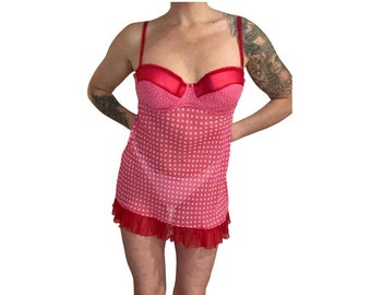 May include: A pink and red polka dot lingerie slip with adjustable straps and a ruffled hem.